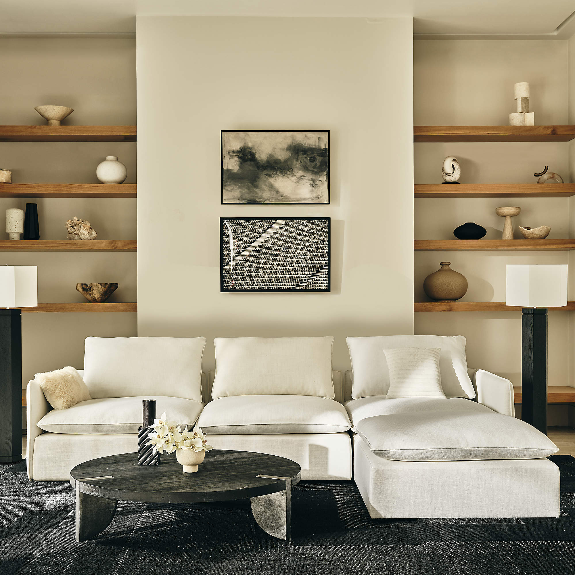 black modern round coffee table in a living room with white sectional. 