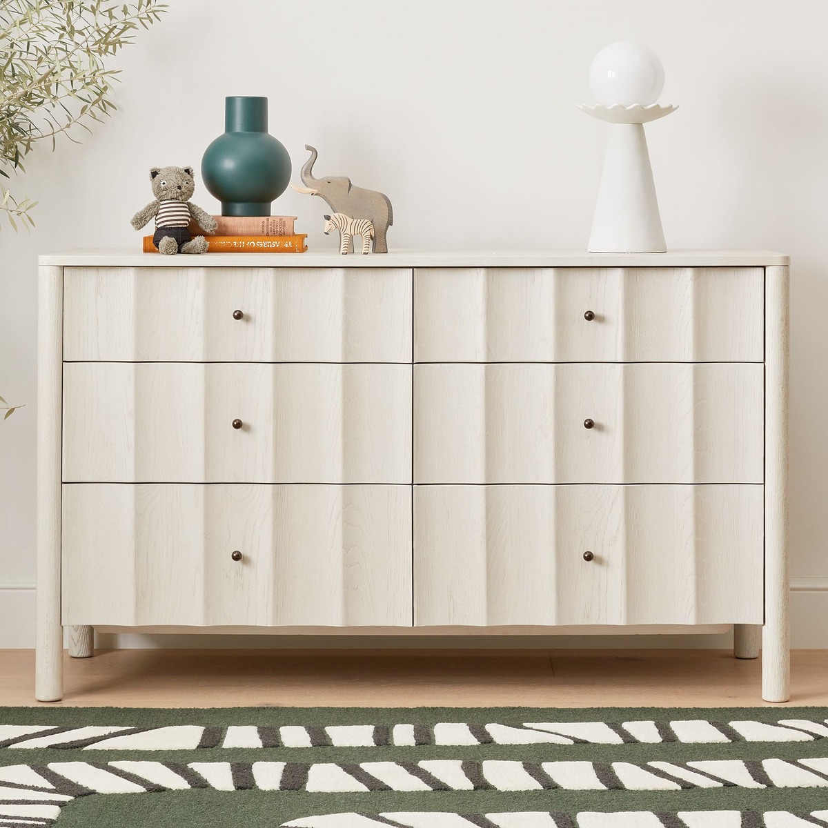 modern scalloped 6-dresser with decorative objects on top. 