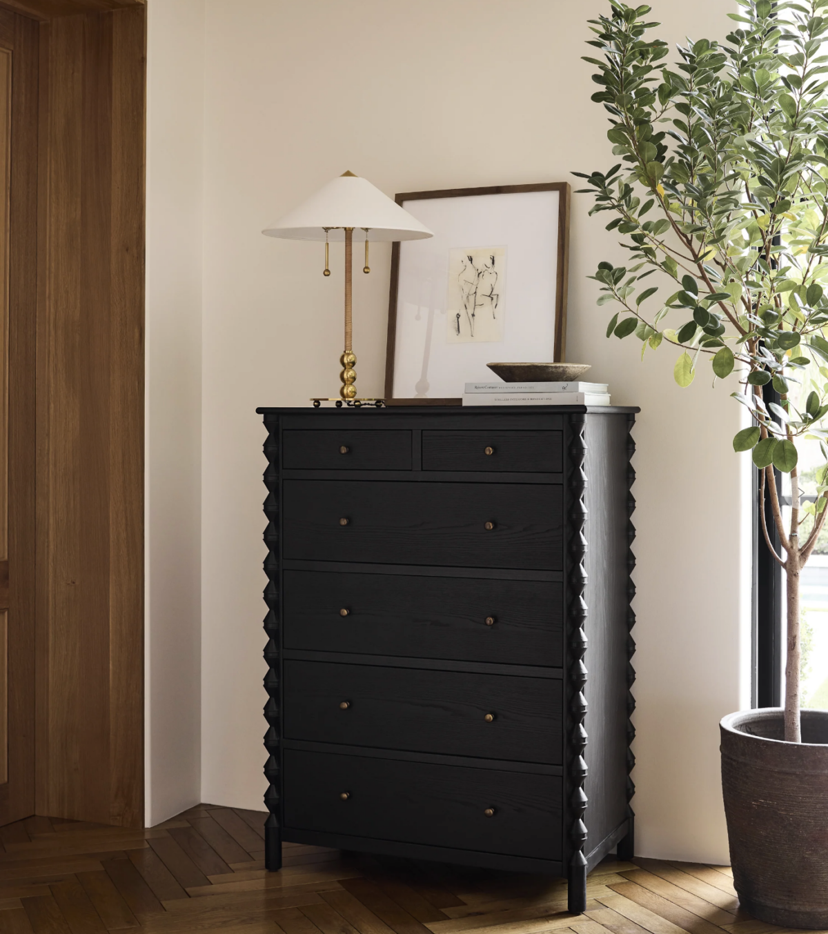 black scalloped dresser with decorative pieces on top. 